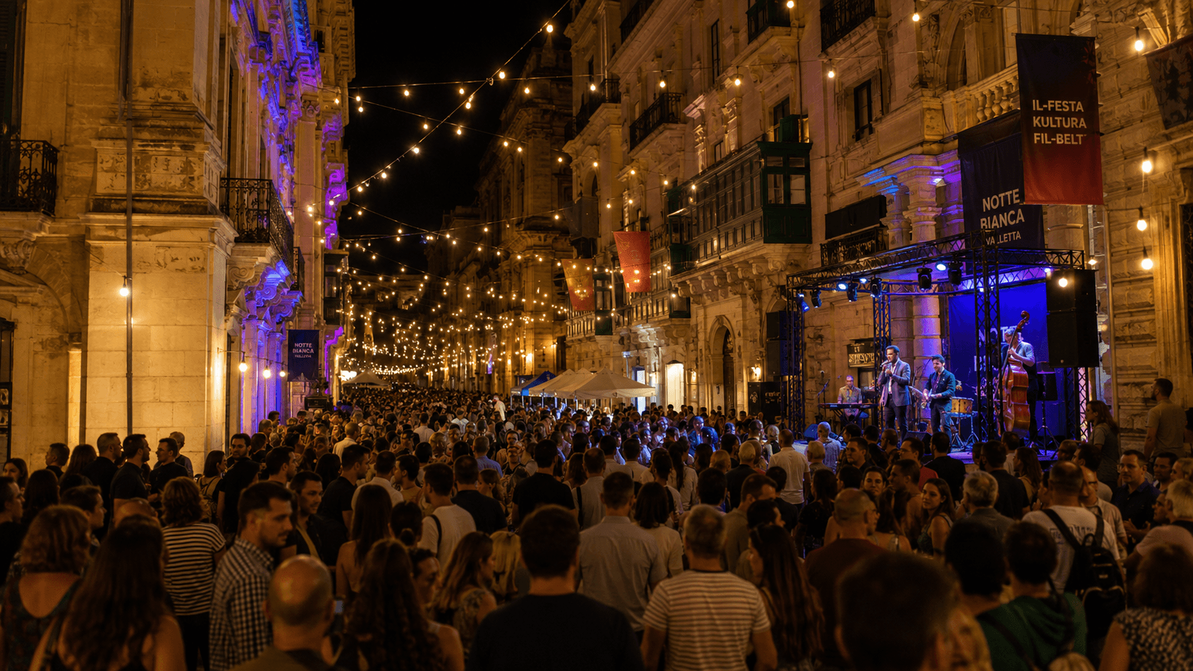 Crowds enjoying live music, lights and cultural activities during Notte Bianca in the illuminated streets of Valletta.